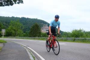 Luc heine in zijn eigen ontworpen wielershirt klimmen in Vianden, Luxemburg